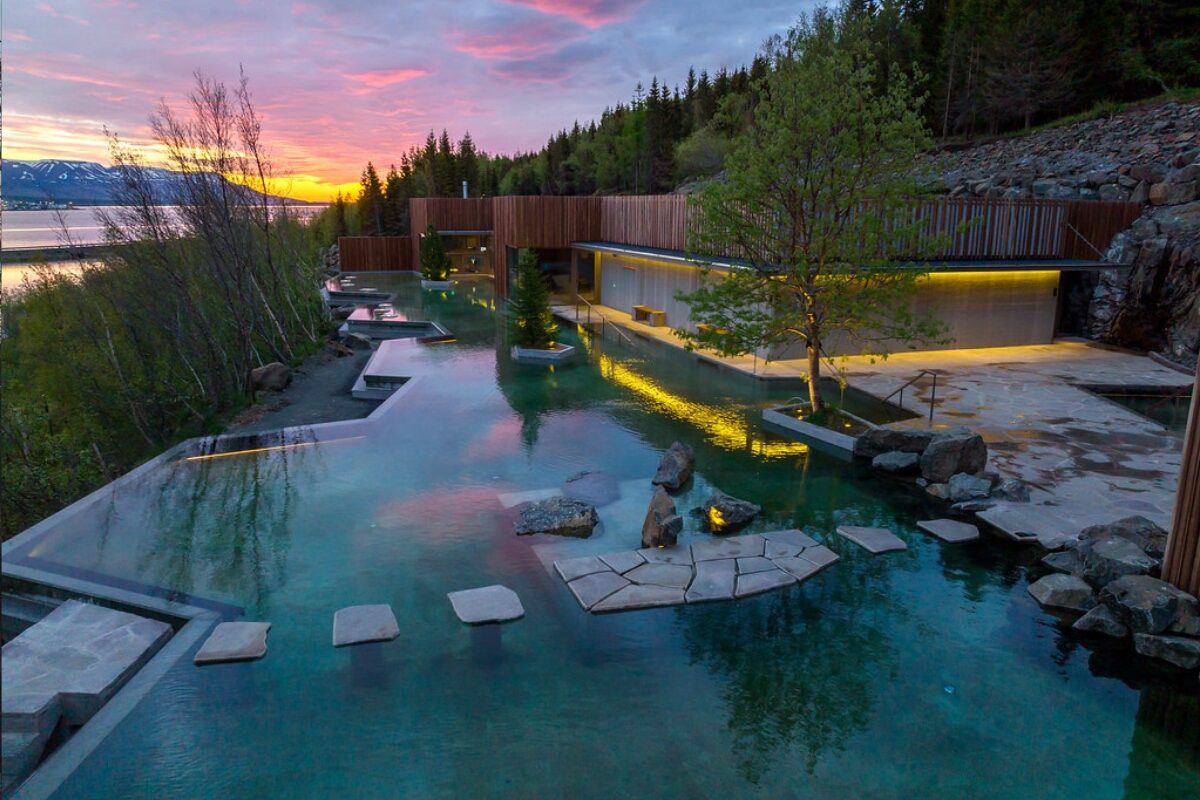 Lush outdoor thermal pools nestled in nature during sunset.