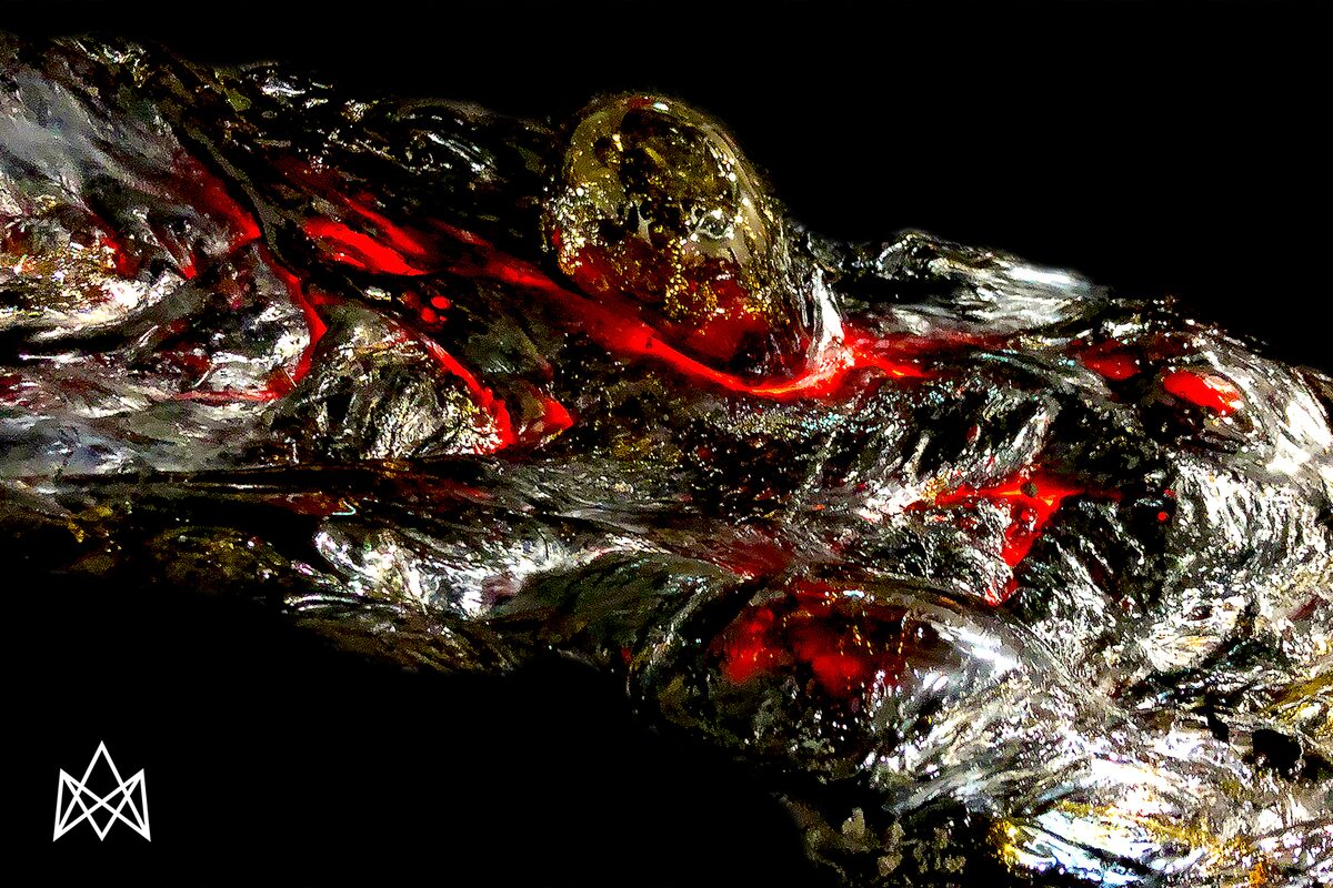 Lava flowing over dark, shiny rock.