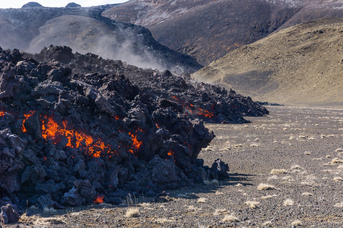 Molten lava flowing over a rocky landscape.