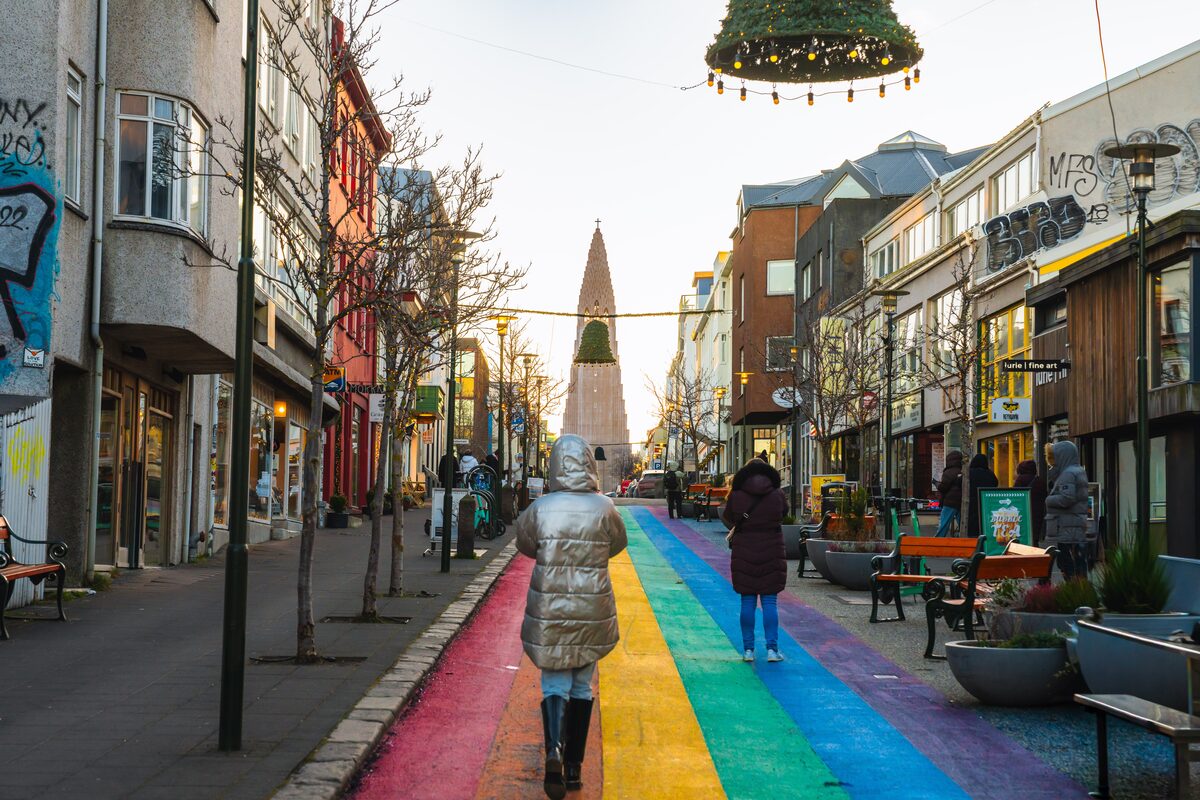 People walking down a rainbow-painted street toward Hallgrímskirkja in Reykjavík.