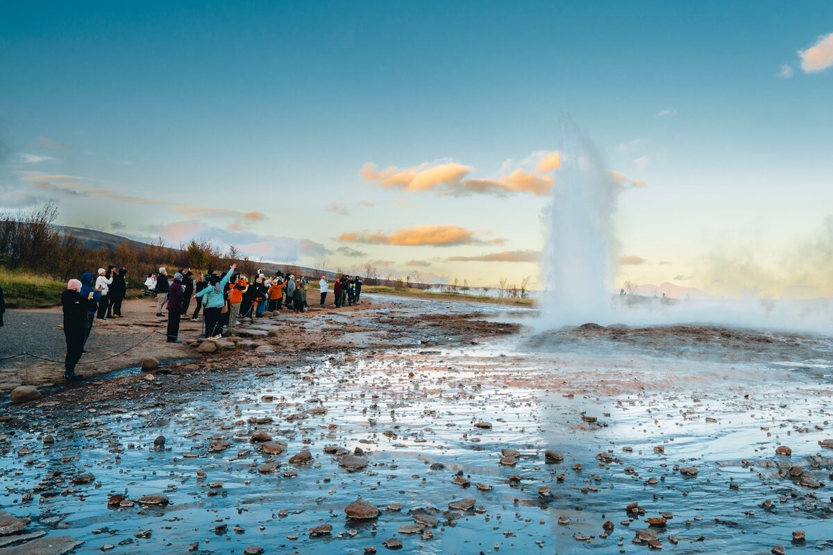 Tourist watching geyser eruption in Iceland