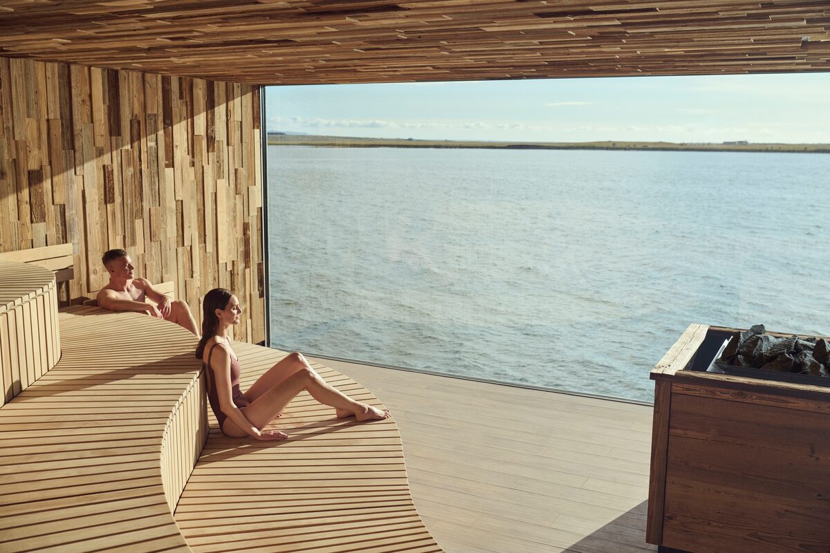 A sauna with a large window overlooking a lake.
