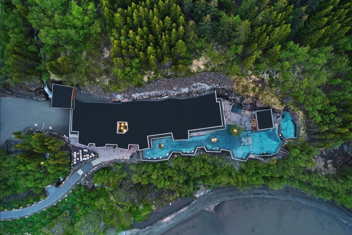 Aerial view of Hvammsvik Hot Springs in Iceland surrounded by forest.
