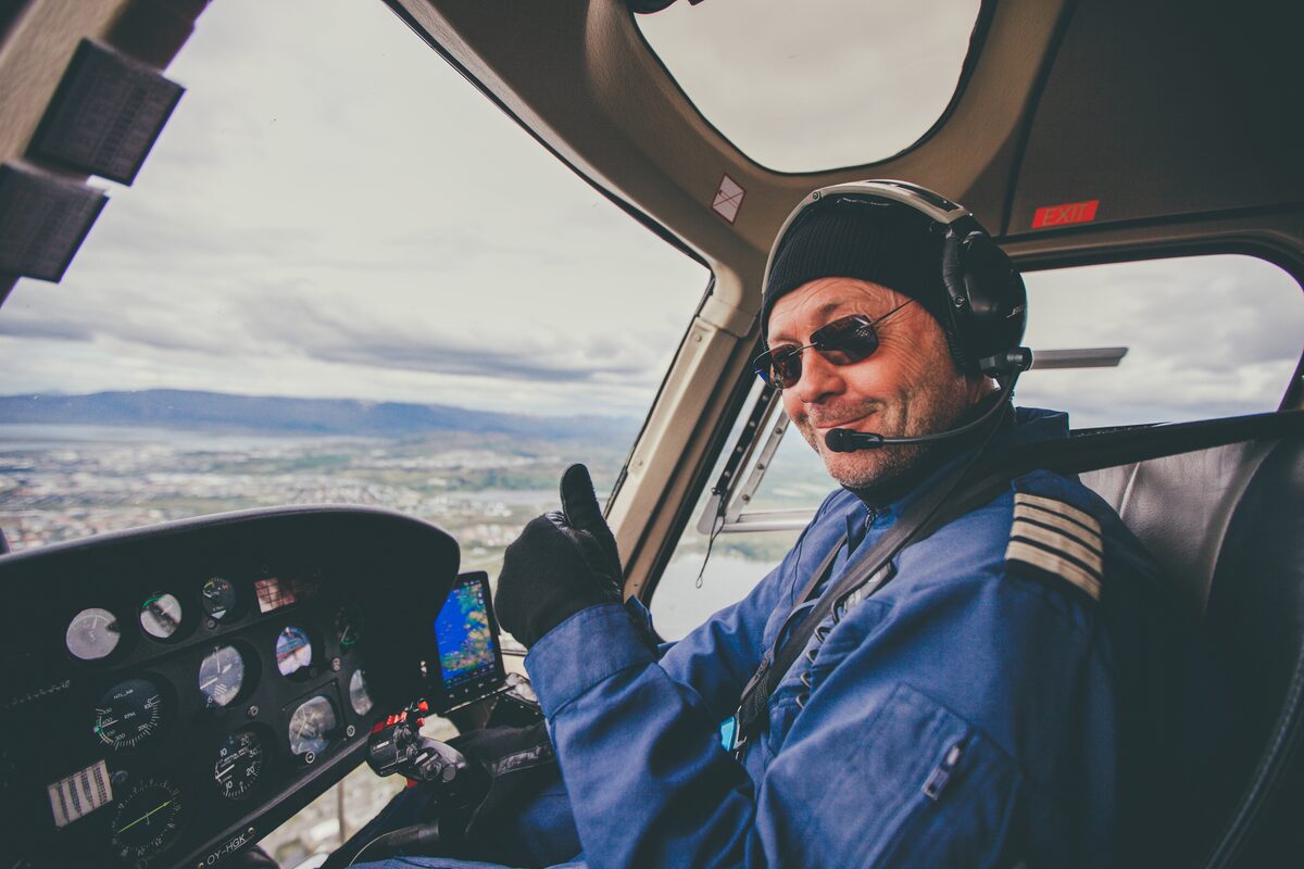 Helicopter pilot smiling and giving a thumbs up.